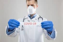 Doctor wearing respiratory mask and holding the Coronavirus blood sample