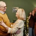 Old man and woman dancing indoors