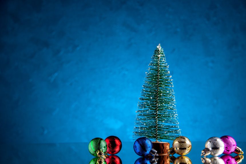 front view small xmas balls mini xmas tree on dark blue background with free space